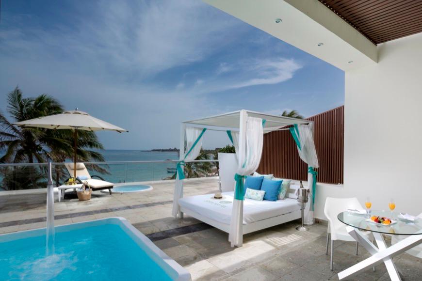 Sala en Master Suite con sillones, mesa, sillas y mini bar en hotel The Sian Ka'an at Grand Tulum